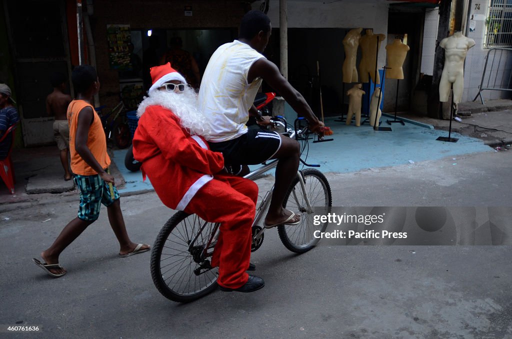 Santa Claus rides in a bike after his  visit at the Favela...