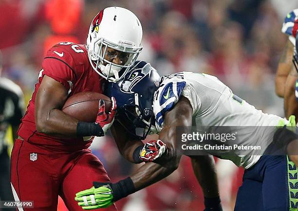 Running back Stepfan Taylor of the Arizona Cardinals is tackled by strong safety Kam Chancellor of the Seattle Seahawks while rushing the football in...
