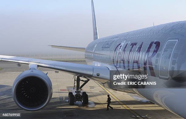 Person walks near one of the two Airbus A350-900 aircrafts for the Qatar Airways company on December 22, 2014 at the Airbus Group center in Toulouse,...