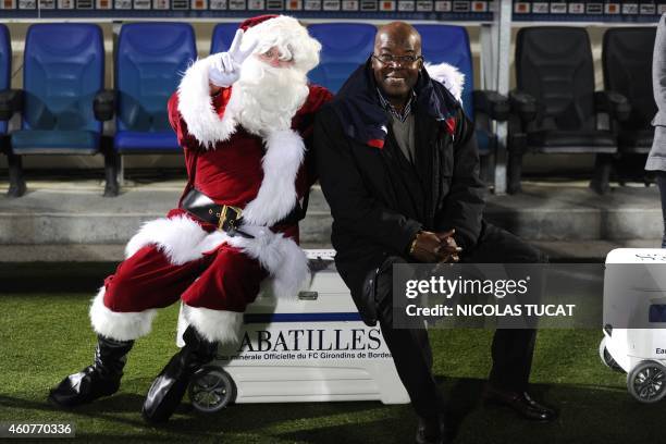 Former French national team player Marius Tresor poses with a person wearing a Santa Claus costume prior to the French L1 football match between...