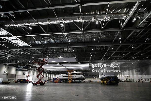 Stardust luxury yacht, manufactured by Sunseeker International Ltd., left, sits alongside another luxury yacht inside the halls of the ExCel...