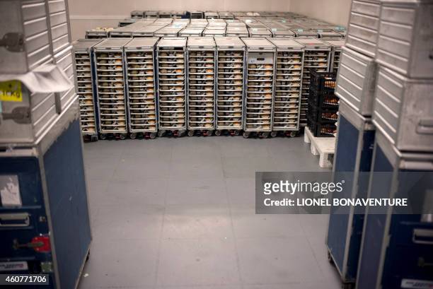 This photo taken on December 8, 2014 shows airplane food trolleys loaded with meal trays at airline catering company Servair's factory at Paris'...