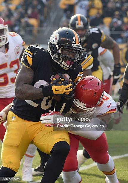 Running back Le'Veon Bell of the Pittsburgh Steelers is tackled by linebacker Josh Mauga of the Kansas City Chiefs during a game at Heinz Field on...