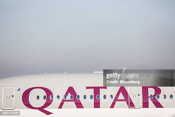 Passenger windows and airline livery sit on the side of Qatar Airways Ltd.'s first Airbus A350 passenger aircraft during a delivery ceremony at the...