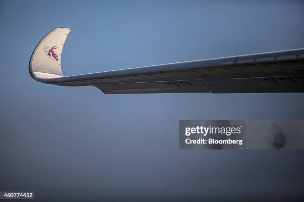 The Qatar Airways Ltd.'s logo sits on the curved wing tip, also known as a winglet, of Qatar Airways first Airbus A350 passenger aircraft during a...