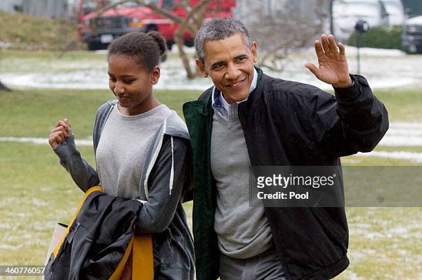 President Barack Obama waves beside his daughter Sasha as they walk across the South Lawn of the White House after arriving by Marine One January 5,...