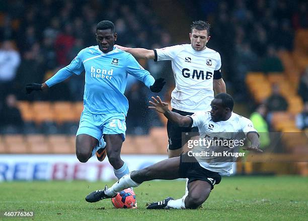 Temitope Obadeyi of Plymouth Argyle holds off Doug Loft and Anthony Griffith of Port Vale during the Budweiser FA Cup third round match between Port...