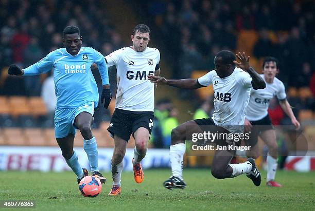 Temitope Obadeyi of Plymouth Argyle holds off Doug Loft and Anthony Griffith of Port Vale during the Budweiser FA Cup third round match between Port...