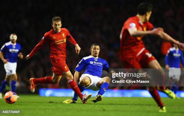 Jonson Clarke-Harris of Oldham offloads the ball as he is challenged by Lucas of Liverpool during the Budweiser FA Cup third round match between...