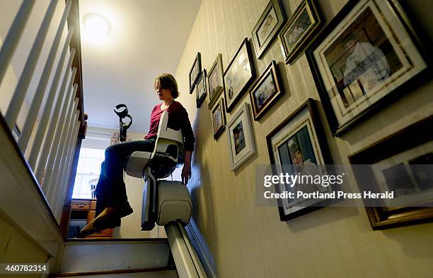 Nikki Gagnon of Westbrook uses a stair lift to go upstairs at her home in Westbrook Wednesday, November 12, 2014. Gagnon has had pain in her feet...