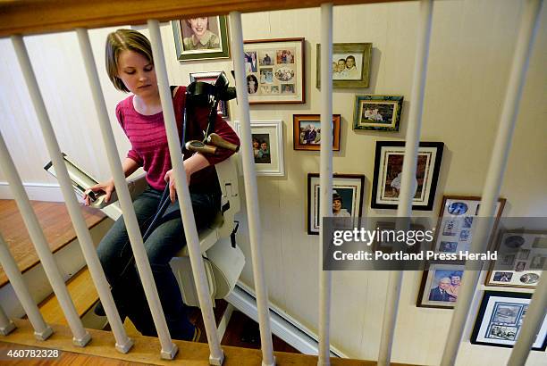 Nikki Gagnon of Westbrook uses a stair lift to go downstairs at her home in Westbrook Wednesday, November 12, 2014. Gagnon has had pain in her feet...