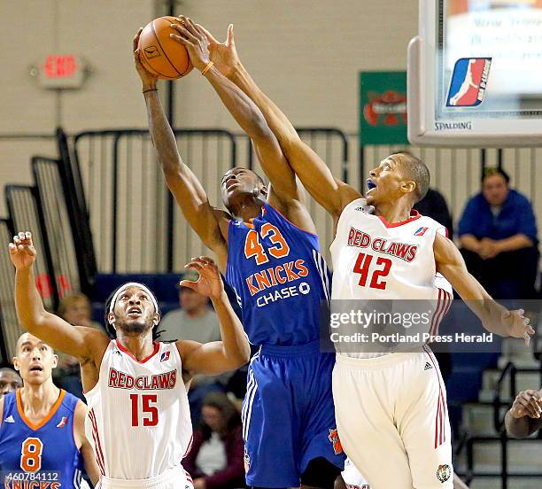 Sherwood Brown, left, and Asauhn Dixon-Tatum, right, both of the Maine Red Claws, fight for a rebound against Thanasis Antetokounmpo of the...