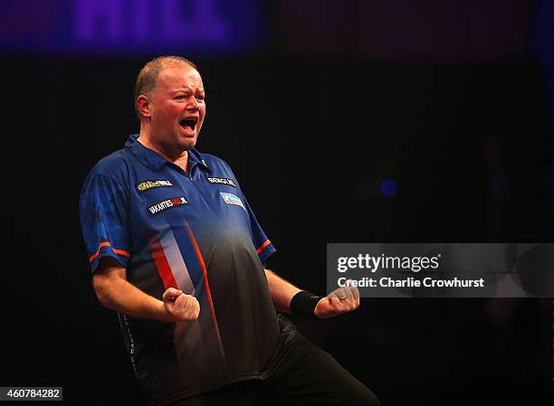 Raymond van Barneveld of Holland celebrates winning his first round match against Rowby-John Rodriguez of Austria during the William Hill PDC World...