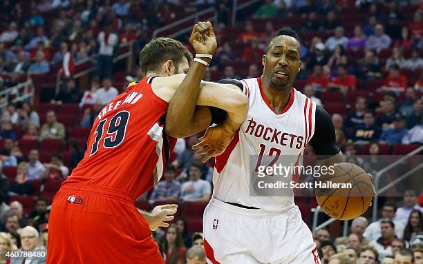 Dwight Howard of the Houston Rockets battles with the basketball against Joel Freeland of the Portland Trail Blazers during their game at the Toyota...