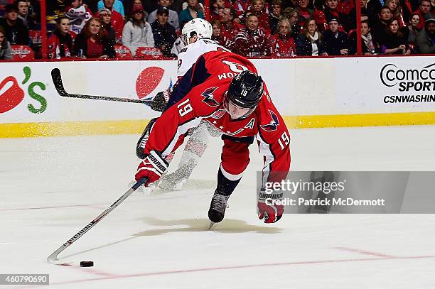 Nicklas Backstrom of the Washington Capitals battles for the puck against Milan Michalek of the Ottawa Senators in the first period during an NHL...