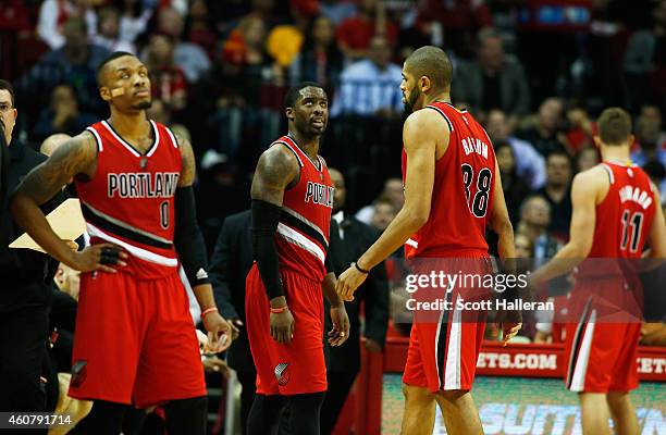 Damian Lillard, Wesley Matthews, Nicolas Batum and Meyers Leonard of the Portland Trail Blazers wait on the court as a play is reviewed during their...