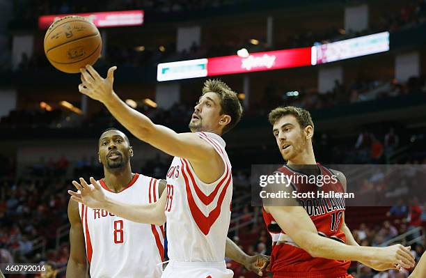 Alexey Shved of the Houston Rockets battles for the basketball with Victor Claver of the Portland Trail Blazers during their game at the Toyota...