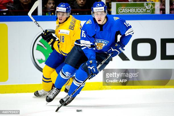 Finland's Juuso Vainio controls the puck in front of Sweden's Andre Burakovsky during the World Junior Ice Hockey Championships final match between...