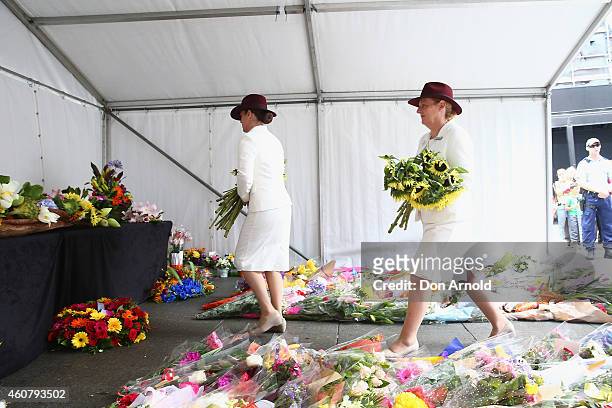 Funeral directors lay flowers at a wreath laying ceremony after the funeral for Tori Johnson, at Martin Place on December 23, 2014 in Sydney,...