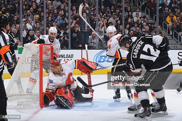 Marian Gaborik of the Los Angeles Kings shoots the puck against Jonas Hiller of the Calgary Flames as Corey Potter and Kris Russell of the Calgary...