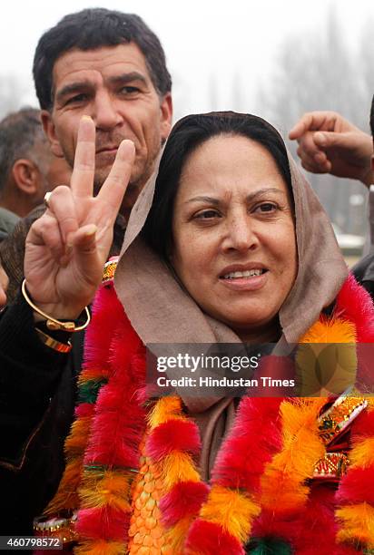 Peoples Democratic Party candidate from Hazratbal constituency Asiya Naqash gestures after winning outside a counting center on December 23, 2014 in...