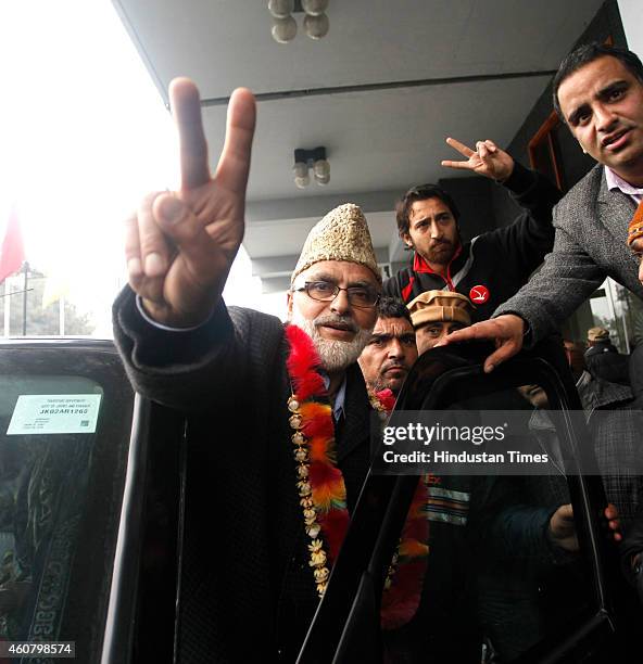 National Conference candidate from Khanyar seat Ali Mohammad Sagar flashes a victory sign to the media outside a counting center on December 23, 2014...