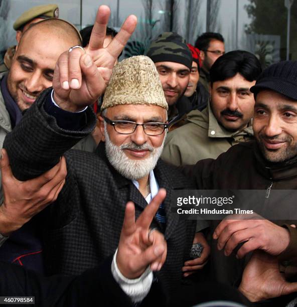 National Conference candidate from Khanyar seat Ali Mohammad Sagar flashes a victory sign to the media outside a counting center on December 23, 2014...