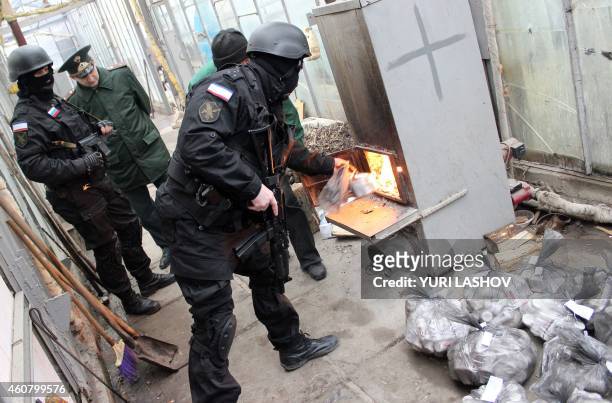 Russian Federal Drug Control Service officers burn bags of synthetic opioid Methadone during an operation in Simferopol on December 23, 2014. Some 30...