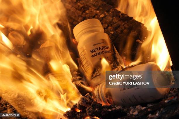 Bottles of synthetic opioid Methadone are burnt during an operation by Russian Federal Drug Control Service officers in Simferopol on December 23,...