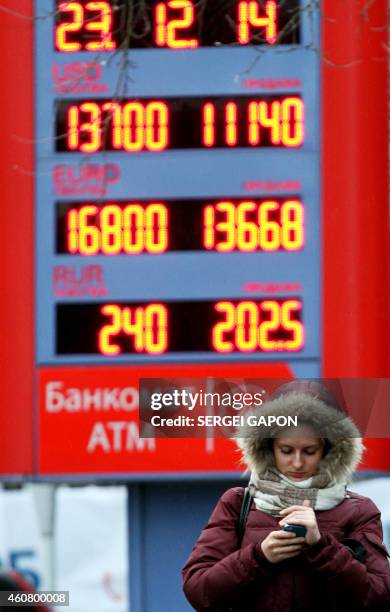 Woman walks past a currency exchange board in central Minsk on December 23, 2014. Belarus blocked online stores and news websites Sunday, in an...