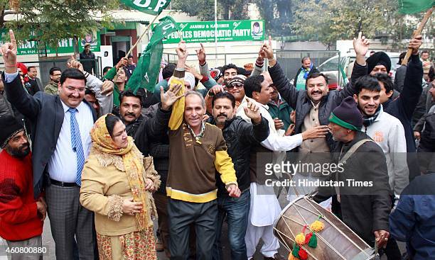 Supporters celebrate after good results in assembly polls outside their party headquarters on December 23, 2014 in Jammu, India. PDP emerged as...