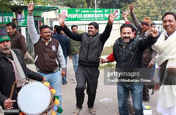 Supporters celebrate after good results in assembly polls outside their party headquarters on December 23, 2014 in Jammu, India. PDP emerged as...