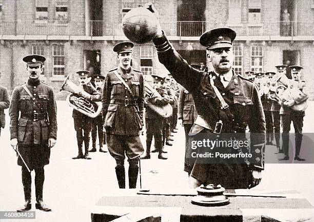 Lieutenant Colonel H P Treeby DSO holds aloft one of four footballs which led a charge of the 8th Battalion of the East Surrey Regiment across No...