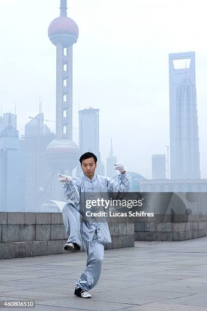 Man practices the Chinese martial art tai-chi at dawn on the Bund on February 1, 2009 in front of the Oriental Pearl tower and the World Financial...