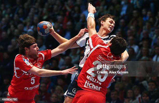 Hampus Wanne of Flensburg-Handewitt is challenged by Johannes Sellin and Michael Mueller of Melsungen during the DKB Handball Bundesliga match...