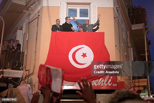 Tunisia's outgoing president Moncef Marzouki greets his supporters at his campaign headquarters a day after his rival Beji Caid Essebsi's victory in...