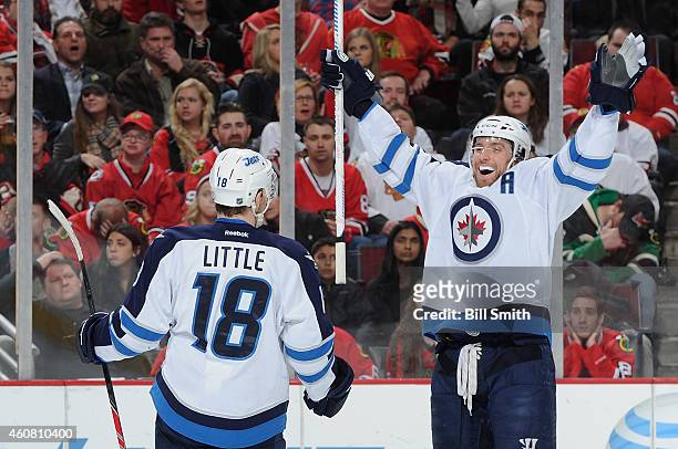 Bryan Little of the Winnipeg Jets turns to celebrate with Blake Wheeler after scoring against the Chicago Blackhawks in the first period during the...
