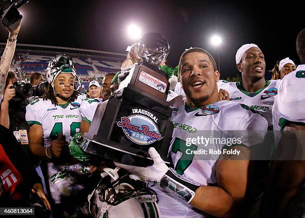 Devon Johnson of the Marshall Thundering Herd holds the championship trophy after the game against the Northern Illinois Huskies at FAU Stadium on...