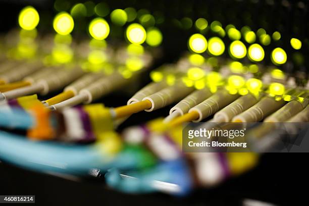 Green LED lights and rows of fibre optic cables are seen feeding into a computer server inside a comms room at an office in London, U.K., on Tuesday,...