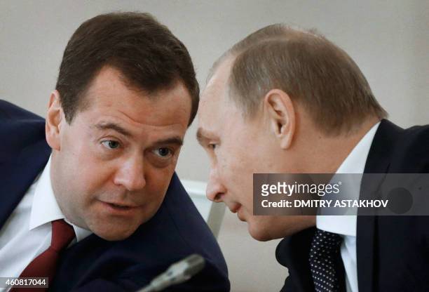 Russian President Vladimir Putin and Russian Prime Minister Dmitry Medvedev confer during a meeting of the State Council and the Presidential Council...
