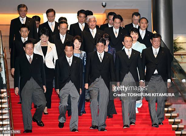 Japanese Prime Minister Shinzo Abe walks down the stairs with his new cabinet members including Japanese Land, Infrastructure, Transport and Tourism...