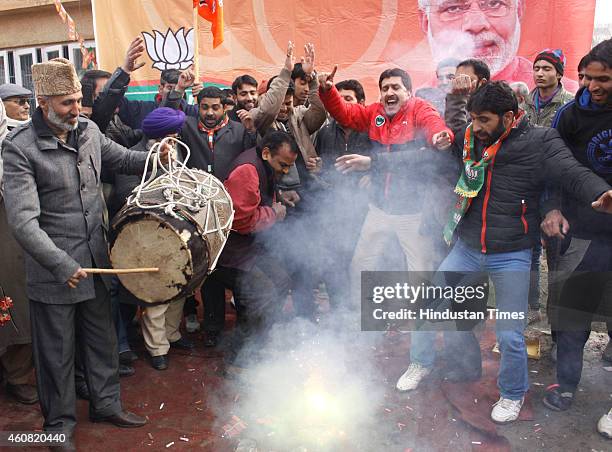 Bharatiya Janata Party supporters dance to celebrate their victory in the Jammu and Kashmir Assembly elections at party Headquarters on December 24,...