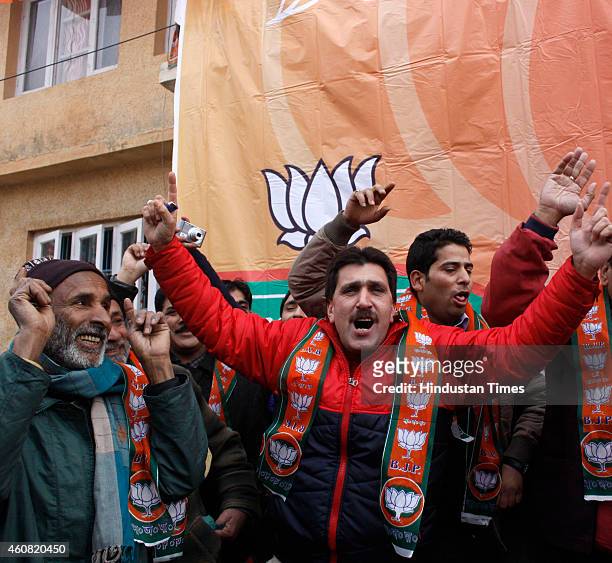 Bharatiya Janata Party supporters dance to celebrate their victory in the Jammu and Kashmir Assembly elections at party Headquarters on December 24,...
