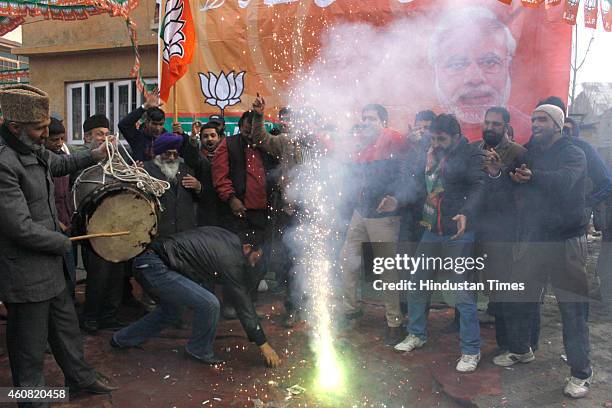 Bharatiya Janata Party supporters dance to celebrate their victory in the Jammu and Kashmir Assembly elections at party Headquarters on December 24,...