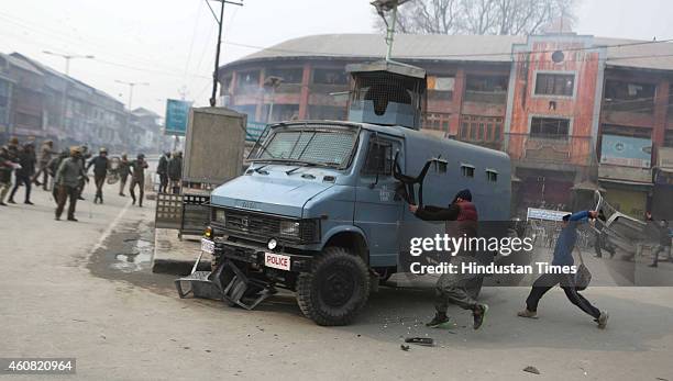 Kashmiri protester throw chair at paramilitary vehicle during a protest at Lal Chowk on December 24, 2014 in Srinagar, India. Clashes erupted as JKLF...