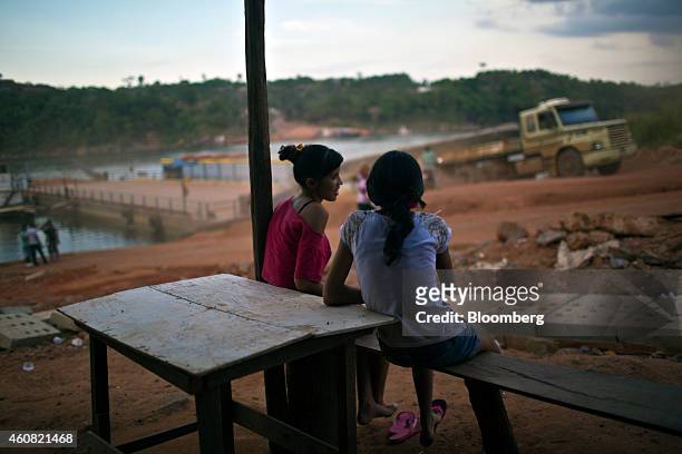 Girls look on as a logging truck disembarks from a ferry on the BR 263 road between Altamira and Anapu, in the southern part of Amazonian state of...