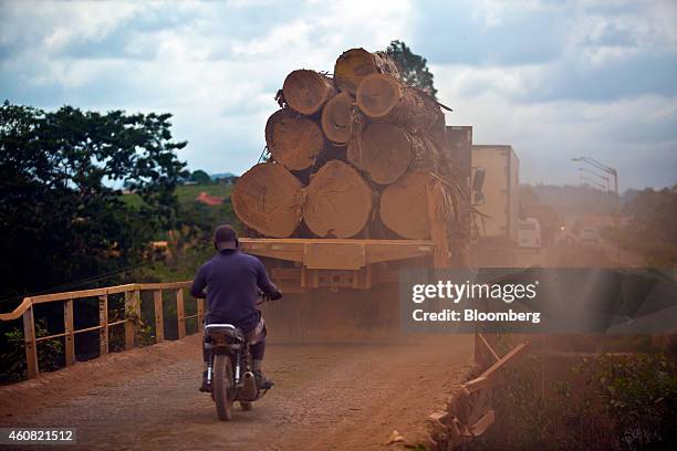 Man rides a motorcycle behind a truck hauling cut logs to a sawmill in Anapu, Brazil, on Wednesday, Dec. 17, 2014. The rate of deforestation Brazil's...