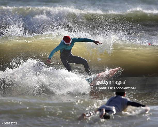 Surfers don Santa outfits during the Surfing Santas of Cocoa Beach fundraiser in Cocoa Beach, Fla., on Wednesday, Dec. 24, 2014. Hundreds dressed in...