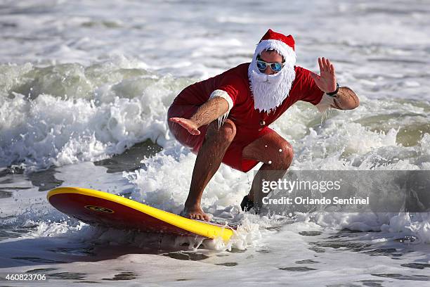 Surfers don Santa outfits during the Surfing Santas of Cocoa Beach fundraiser in Cocoa Beach, Fla., on Wednesday, Dec. 24, 2014. Hundreds dressed in...