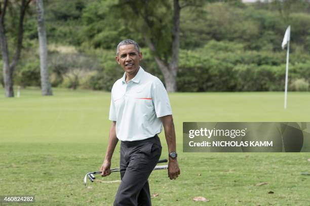 President Barack Obama talks to reporters as he plays golf with Malaysian Prime Minister Najib Razzak at Marine Corps Base Hawaii on December 24,...